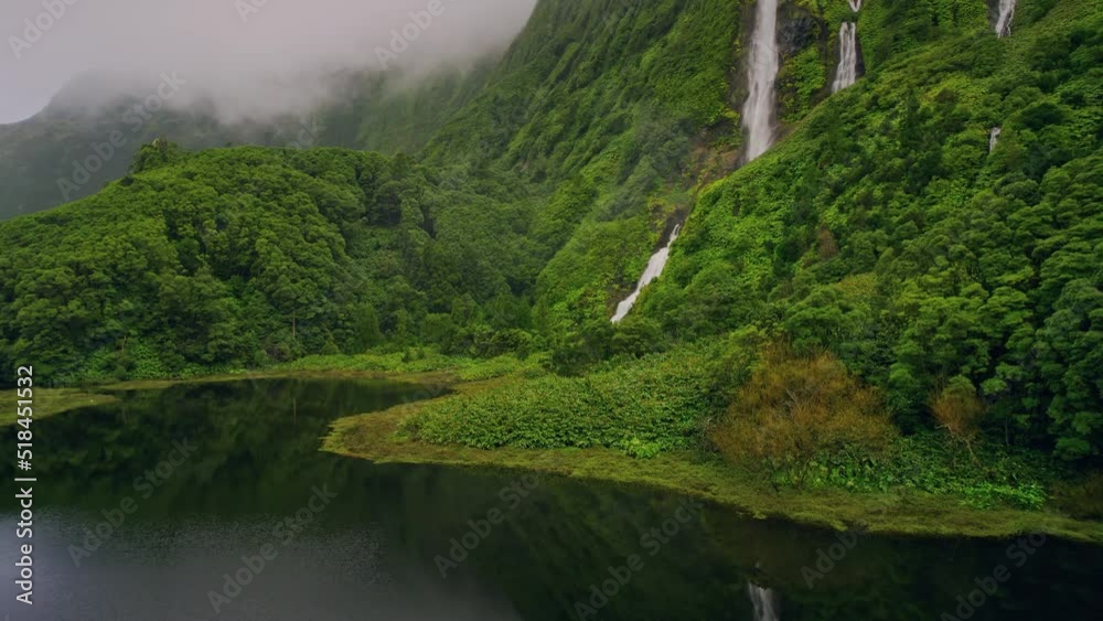 green mountains with waterfalls of Poco Ribeira do Ferreiro, Alagoinha, Flores Island, Azores, Portugal, Europe. Aerial view of amazing natural landscape with cliffs, 4k footage