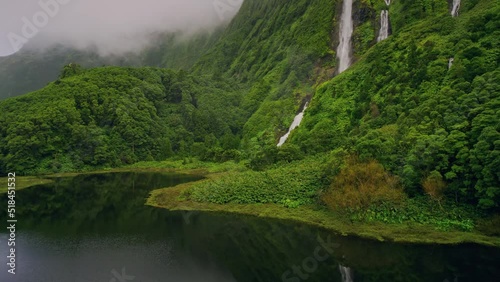 green mountains with waterfalls of Poco Ribeira do Ferreiro, Alagoinha, Flores Island, Azores, Portugal, Europe. Aerial view of amazing natural landscape with cliffs, 4k footage photo