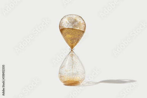 Hourglass with flowing golden sand inside photo
