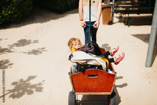 Little girl in a handcart outdoors