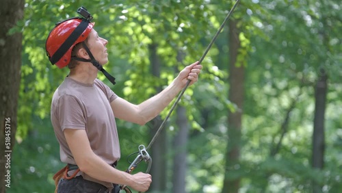 Man belays his partner climber with belaying device and rope. Climber's handsman holding equipment for rock mountaineering security photo