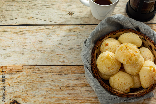 many cheese breads or 'pão de queijo' in basket and french press coffee maker, with fabric around photo