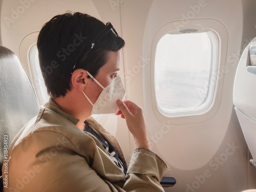 Woman With Medical Mask Flying On A Plane photo