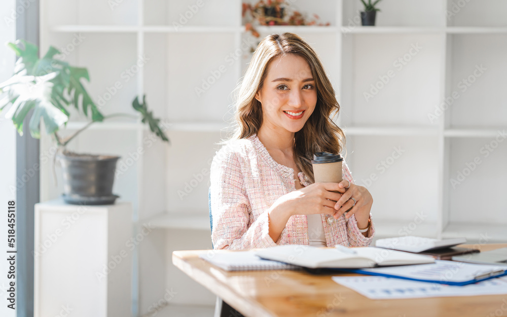 Pretty Asian business woman drinking coffee in office, break time, relax, happy. Pretty Asian business woman drinking coffee in office, break time, relax, happy.