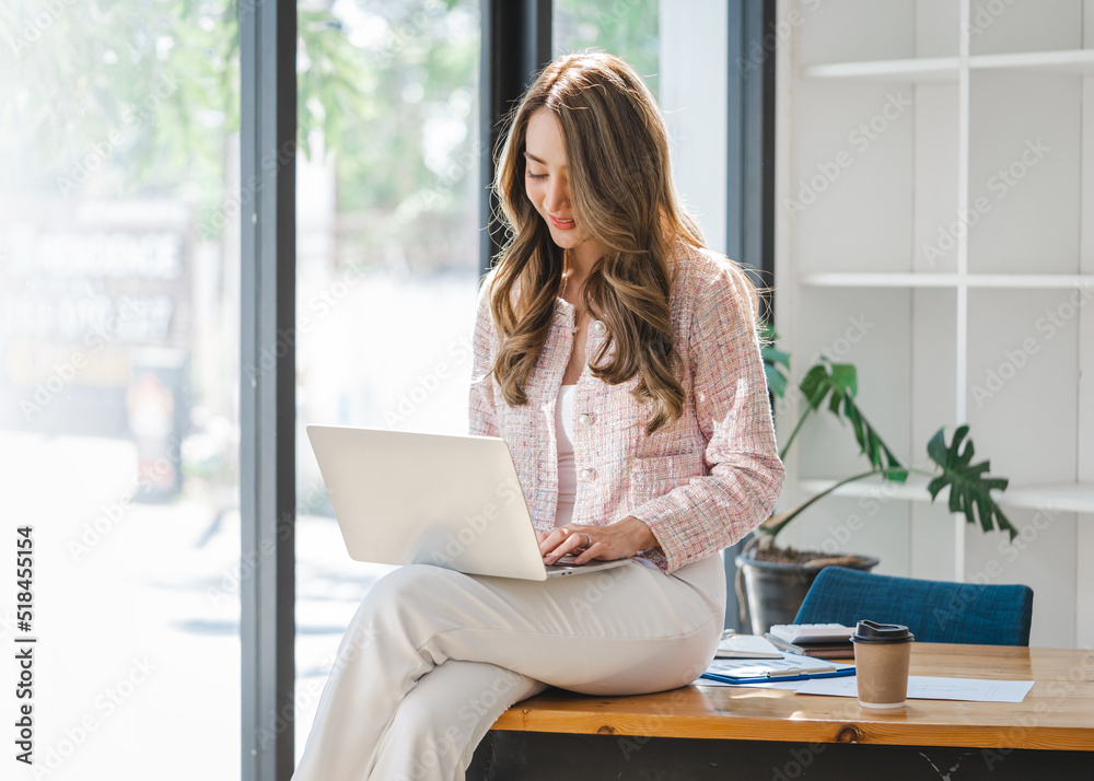 Beautiful young Asian business woman using laptop computer in her office workplace. Beautiful young Asian business woman using laptop computer in her office workplace.