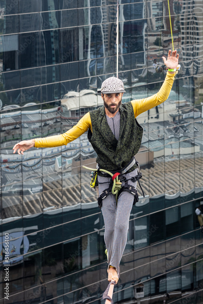 Man doing slackline between two buildings Man doing slackline between two buildings