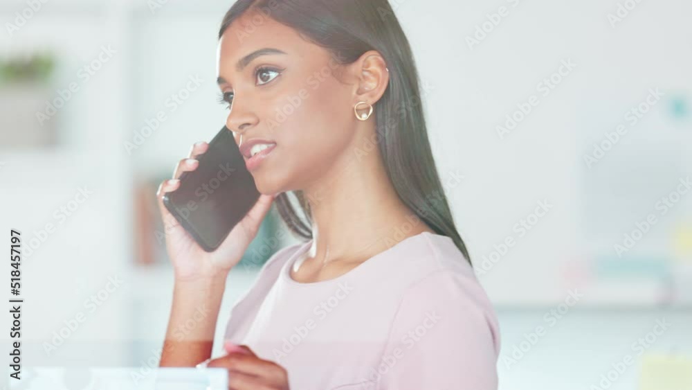 Female designer talking on a phone call and walking inside a modern office or creative startup agency. Casual young indian business woman chatting to colleagues to plan strategy and discuss projects