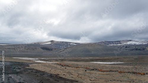 Snow covered mountains above a volcanic landscape at Telefon Bay, Deception Island, Antarctica