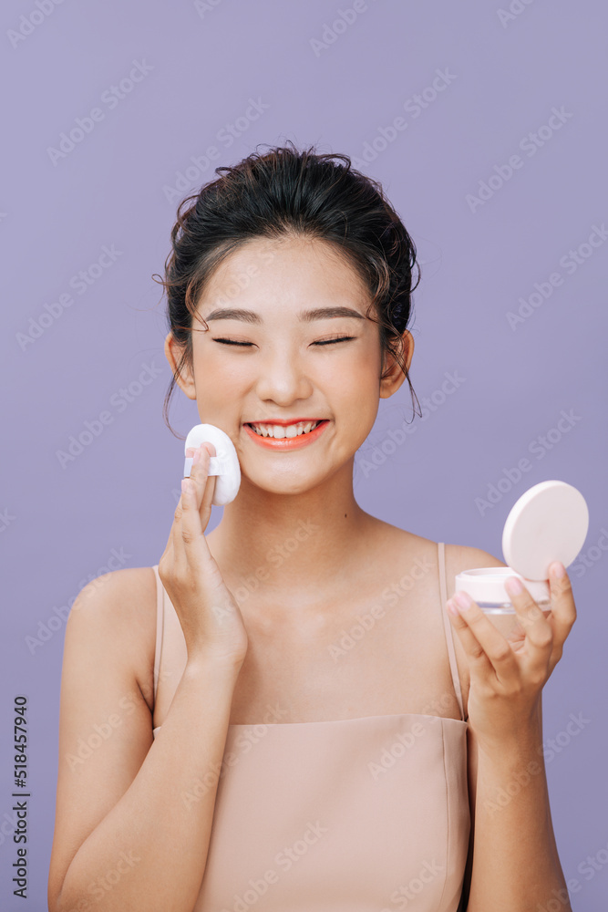 Beautiful asian woman applying blusher on her face with powder Beautiful asian woman applying blusher on her face with powder