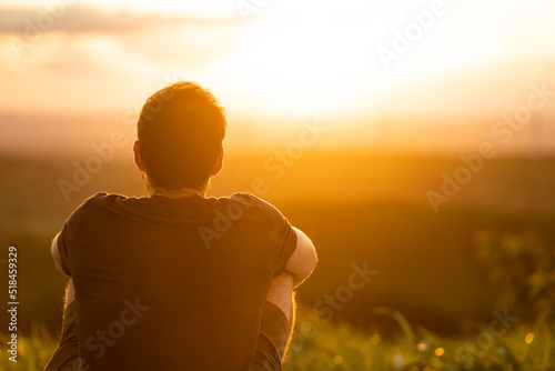 Man sitting appreciating a beautiful sunset.