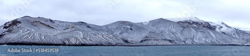 Panorama of snow covered mountains surrounding a crater bay on Deception Island, Antarctica