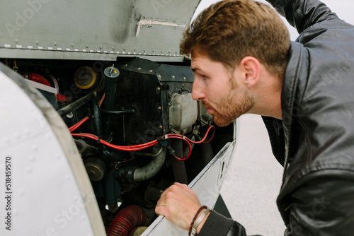 Pilot checking the engine of the plane photo