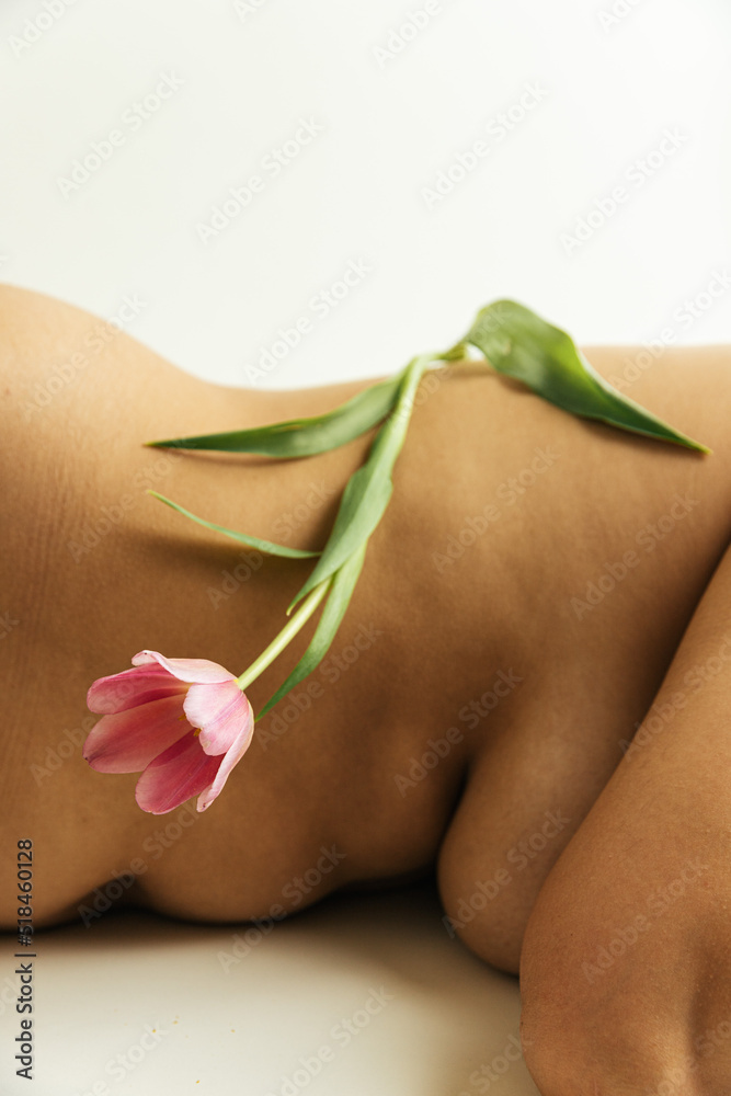 © Sophia Hsin/Stocksy - Tulip balanced on bare skin and curves © Sophia Hsin/Stocksy - Tulip balanced on bare skin and curves