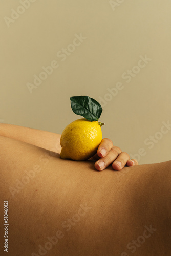 Curve of woman's waist with lemon balanced on top photo