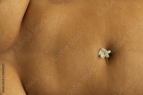 Single jasmine flower on belly button photo