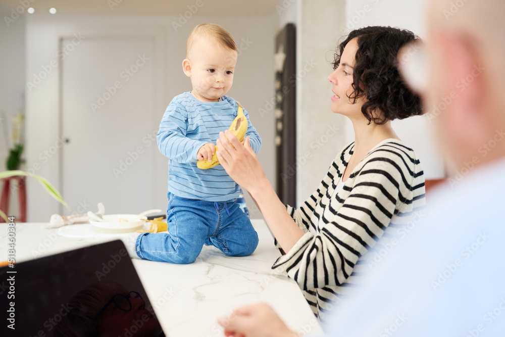 Mother giving banana to son