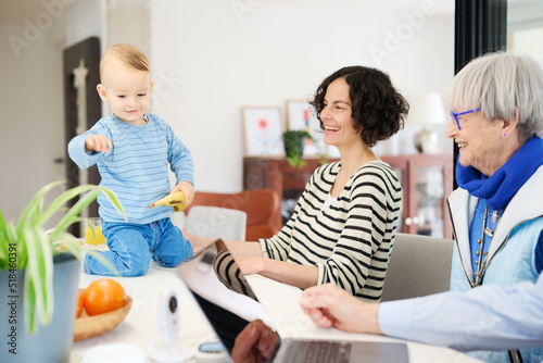 Family laughing at lovely funny toddler on counter. photo