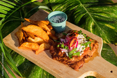 Milanesa potatoes with and a miniature pewter over a wood board  photo