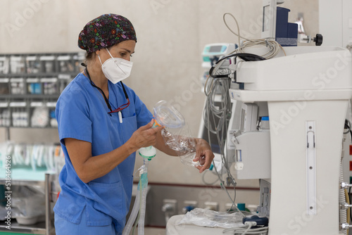 Nurse preparing settings of a mechanical ventilation machine photo