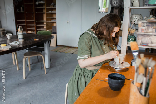 Focused female ceramist at work in the studio photo