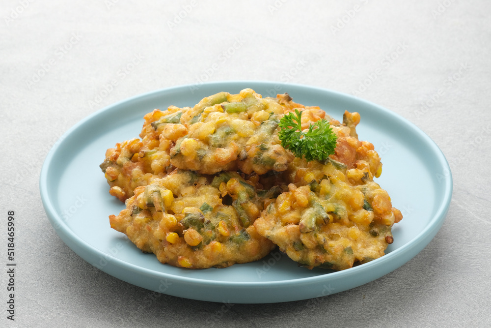 Perkedel Jagung or Bakwan Jagung, corn fritters is Indonesian traditional food. Savoury snack made of corn, egg, flour, spring onion, pepper and salt. Served in plate on grey background.
Perkedel Jagung or Bakwan Jagung, corn fritters is Indonesian traditional food. Savoury snack made of corn, egg, flour, spring onion, pepper and salt. Served in plate on grey background.
