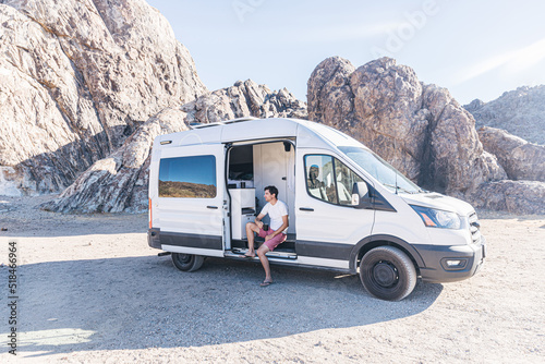 Man drinking coffee sitting in a camper van photo