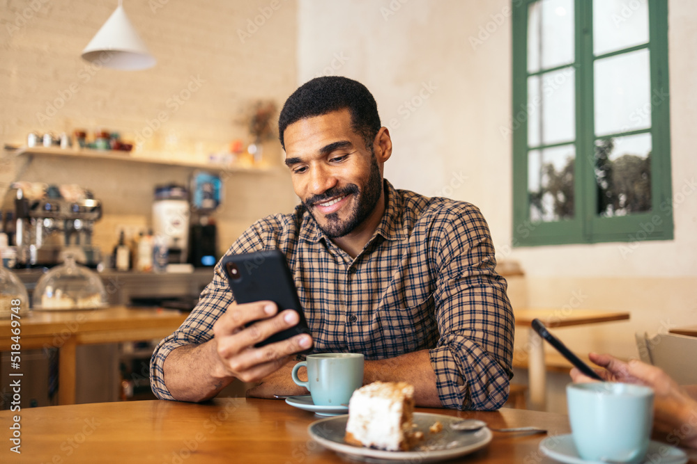 Handsome black man using smartphone in a cafe Handsome black man using smartphone in a cafe