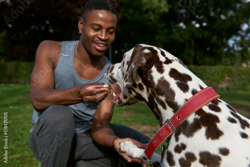 Close up of a men playing with food for his dog photo