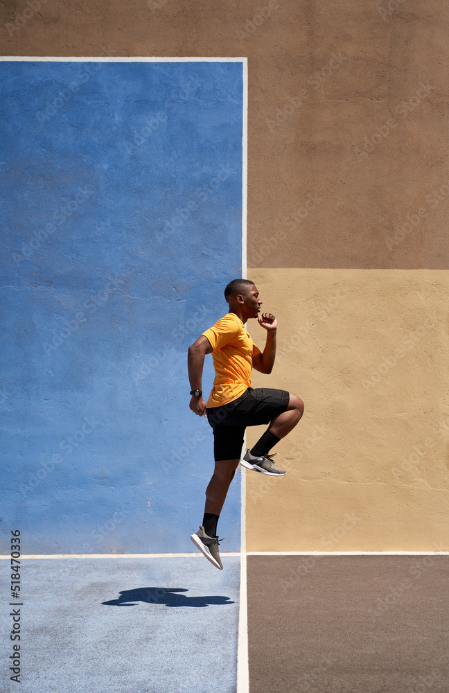 Fit black sprinter running in stadium on sunny day Fit black sprinter running in stadium on sunny day