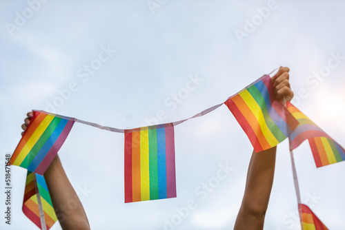 Woman Holding Up LGBTQ+ Pride Flag Banner photo