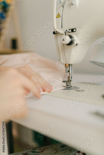 hands of seamstress working on sewing machine photo