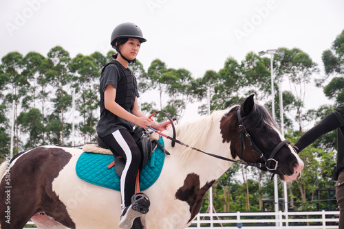 Asian little girl is riding a horse. practise