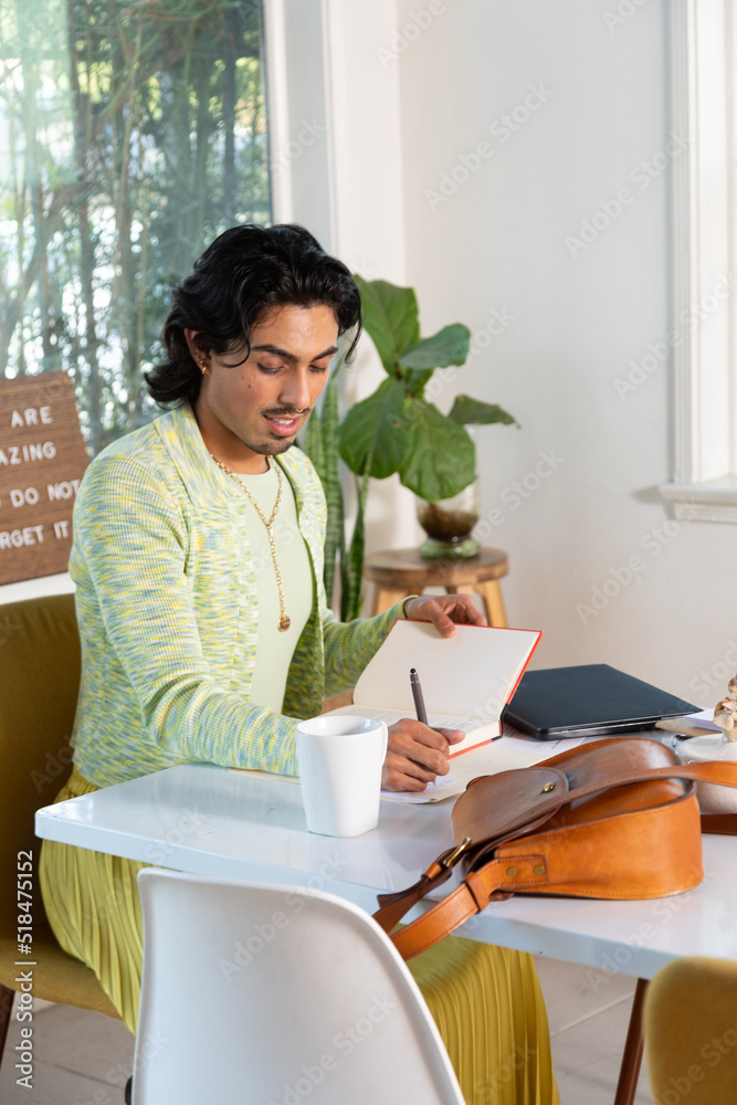 Stylish queer person wearing a yellow skirt working Stylish queer person wearing a yellow skirt working