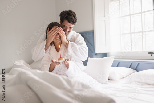 Young beautiful couple in bed giving a surprise photo