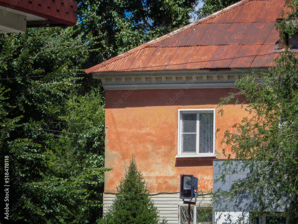 Very old residential building. Apartment block. Green trees. Old architecture. Ust-Kamenogorsk (kazakhstan)