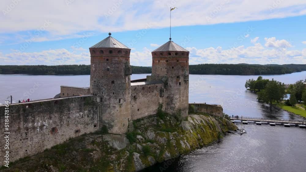 Drone flying along medieval castle walls, approaching a historical tower in Olavinlinna castle on a beautiful summer day in Savonlinna, Finland Drone flying along medieval castle walls, approaching a historical tower in Olavinlinna castle on a beautiful summer day in Savonlinna, Finland