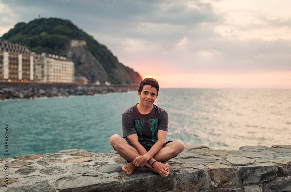 Portrait of a smiling sitting teen near the sea Portrait of a smiling sitting teen near the sea