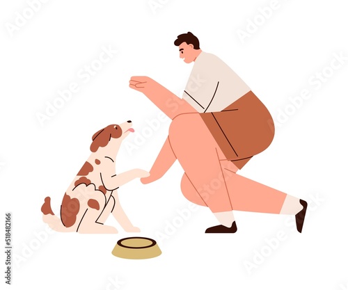 Dog obeying to giving paw command. Man training, educating doggy. Trainer ges...