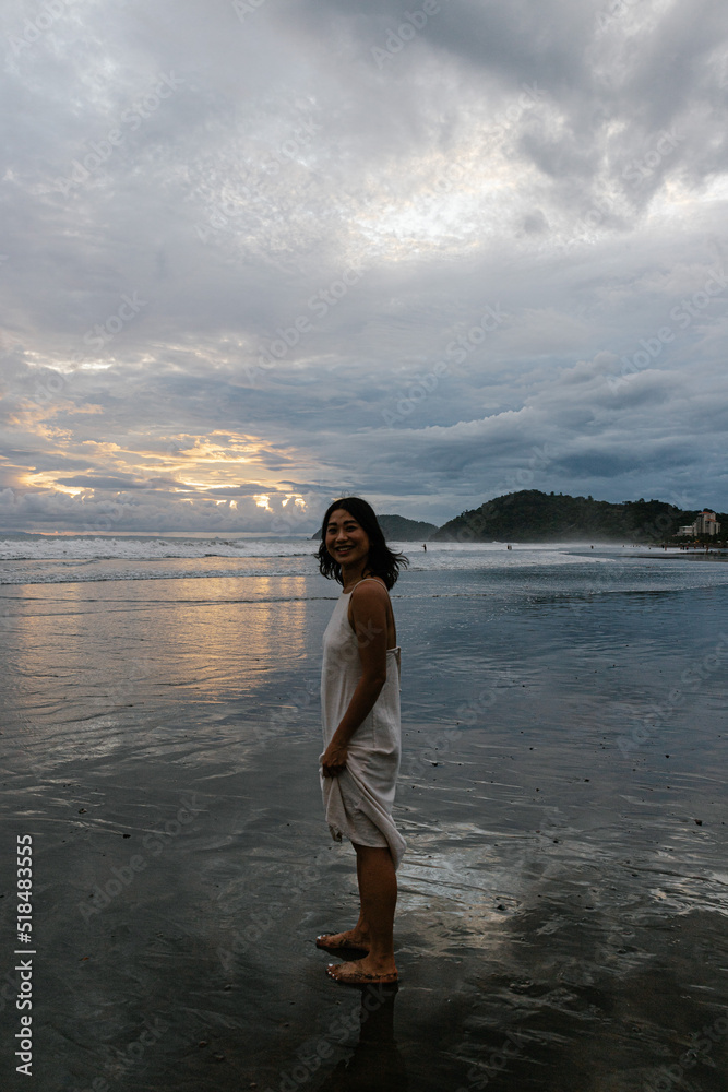 Young woman running across the beach during sunset Young woman running across the beach during sunset