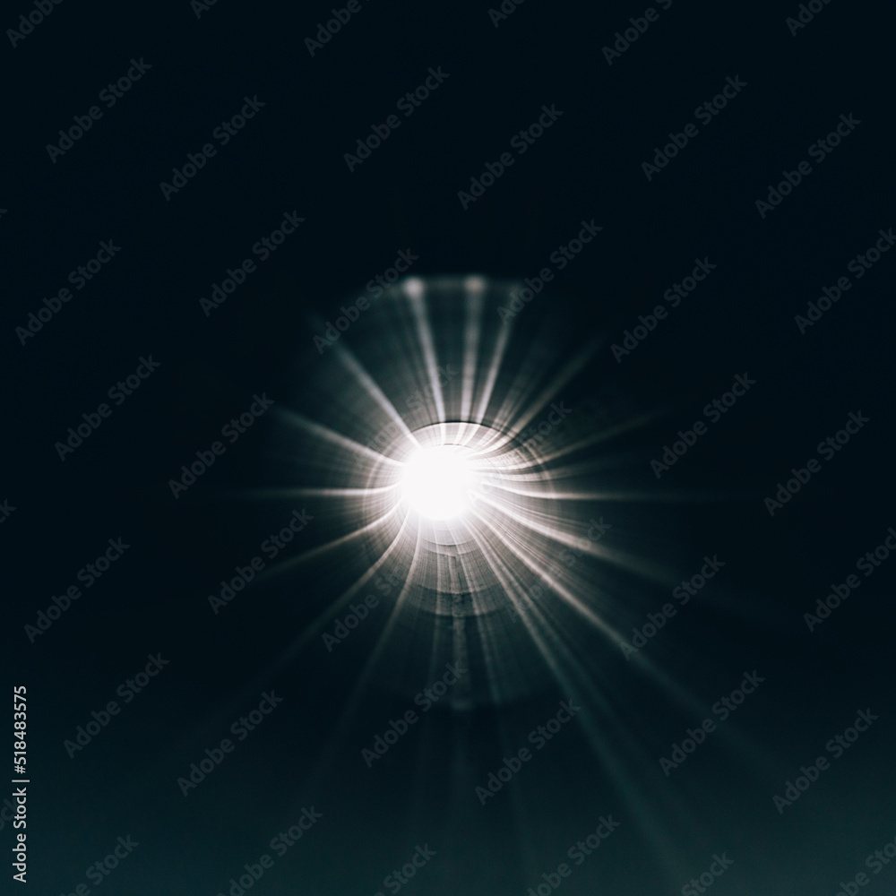 A bright light shining through small hole of industrial pipe, close up A bright light shining through small hole of industrial pipe, close up