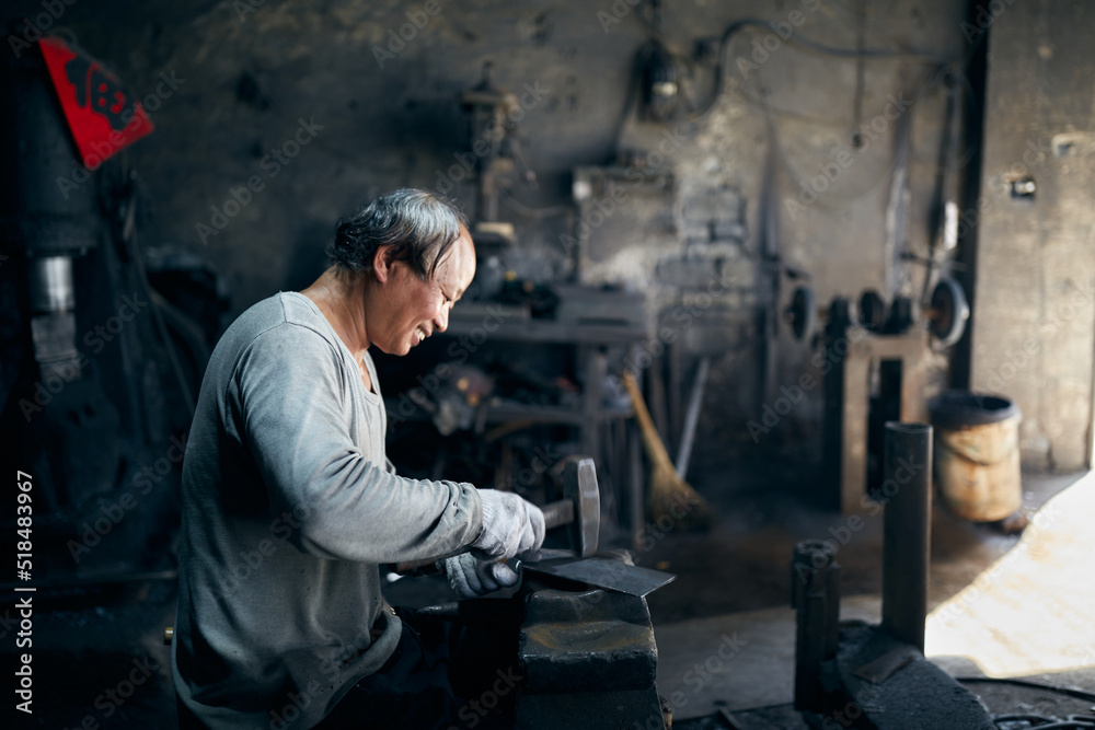An East Asian Ironworker manufactures a Chinese kitchen knife. An East Asian Ironworker manufactures a Chinese kitchen knife.