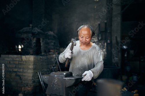 Wallpaper Mural An East Asian Ironworker manufactures a Chinese kitchen knife. Torontodigital.ca