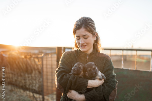 Young woman with puppy dogs on a farm