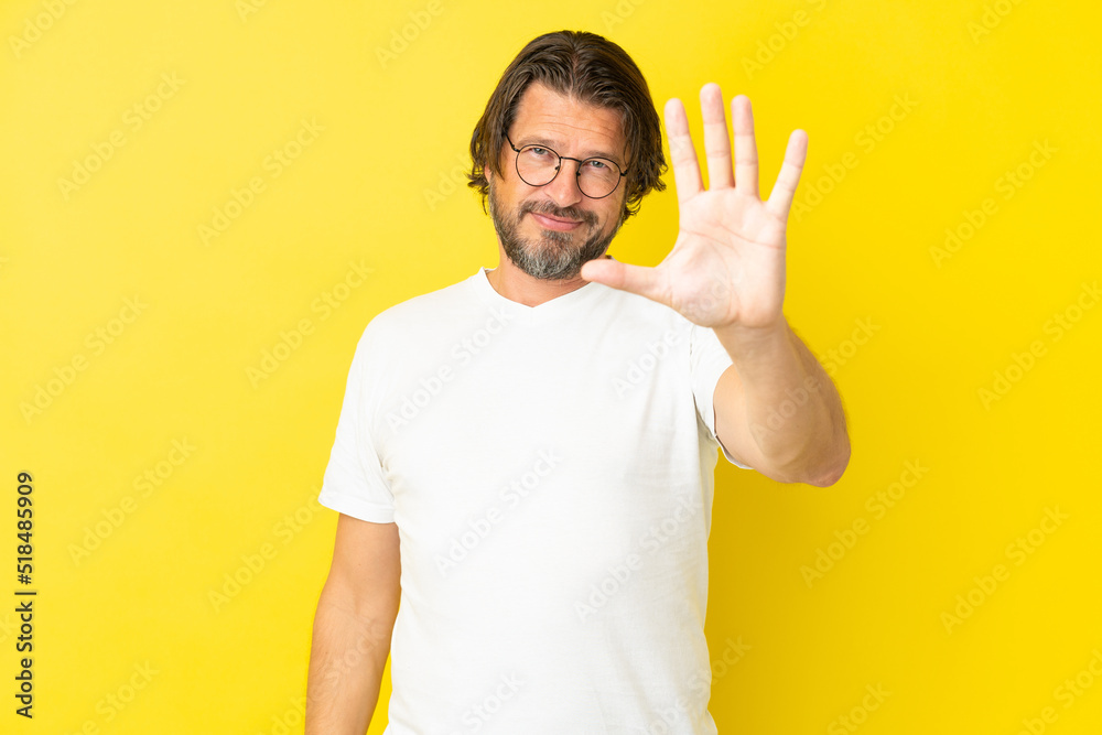 Senior dutch man isolated on yellow background counting five with fingers Senior dutch man isolated on yellow background counting five with fingers