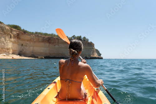 Woman in bikini sitting on kayak in sea