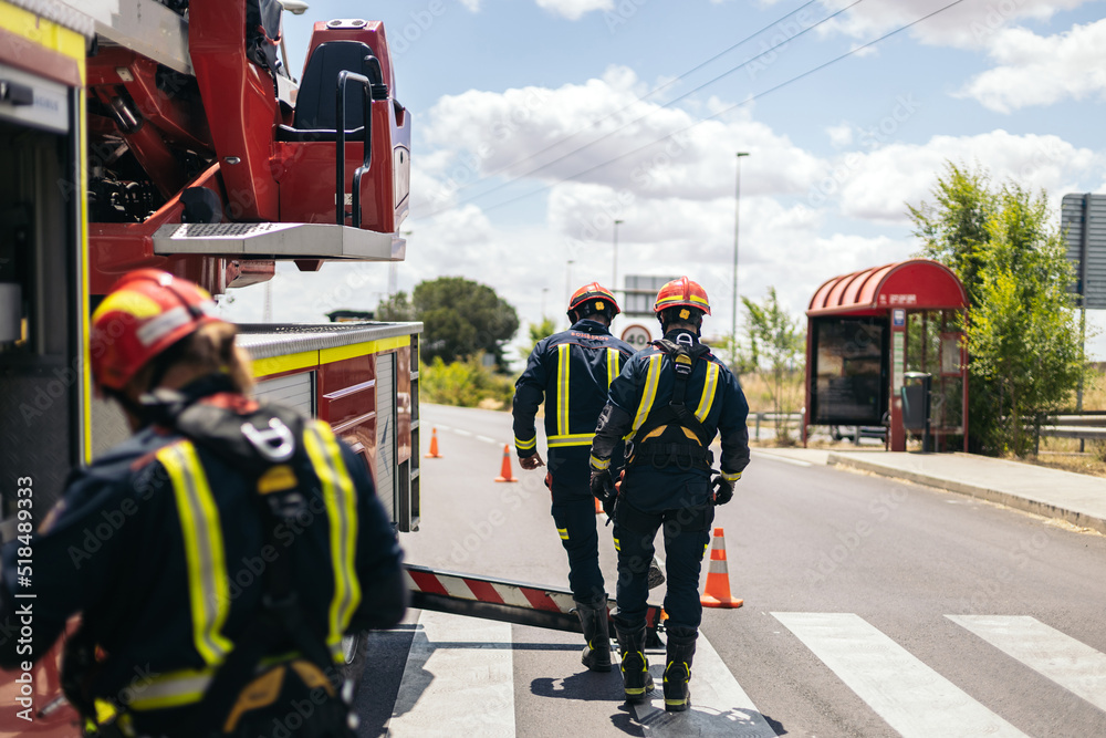 Firefighters working on an emergency intervention with the fire truck Firefighters working on an emergency intervention with the fire truck