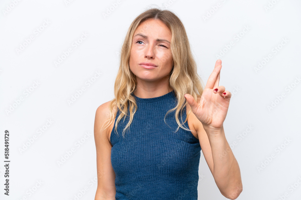 Fototapeta premium Young Russian woman isolated on white background with fingers crossing and wishing the best