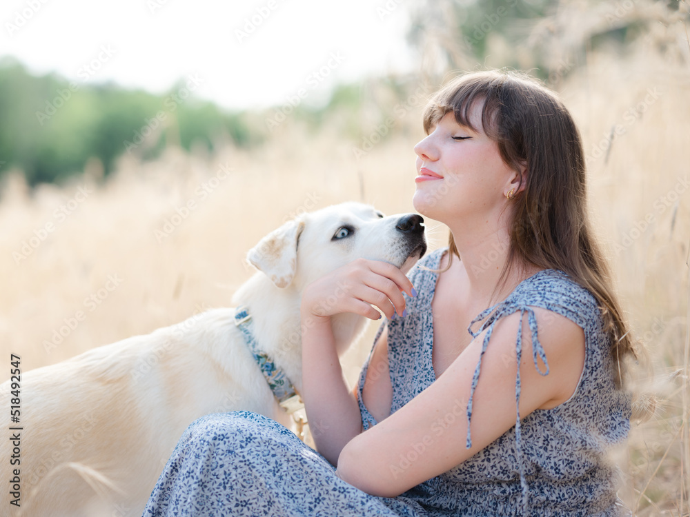 A young woman in a wheat field with her dog A young woman in a wheat field with her dog