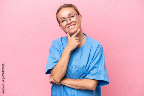 Young nurse doctor woman isolated on pink background smiling © luismolinero