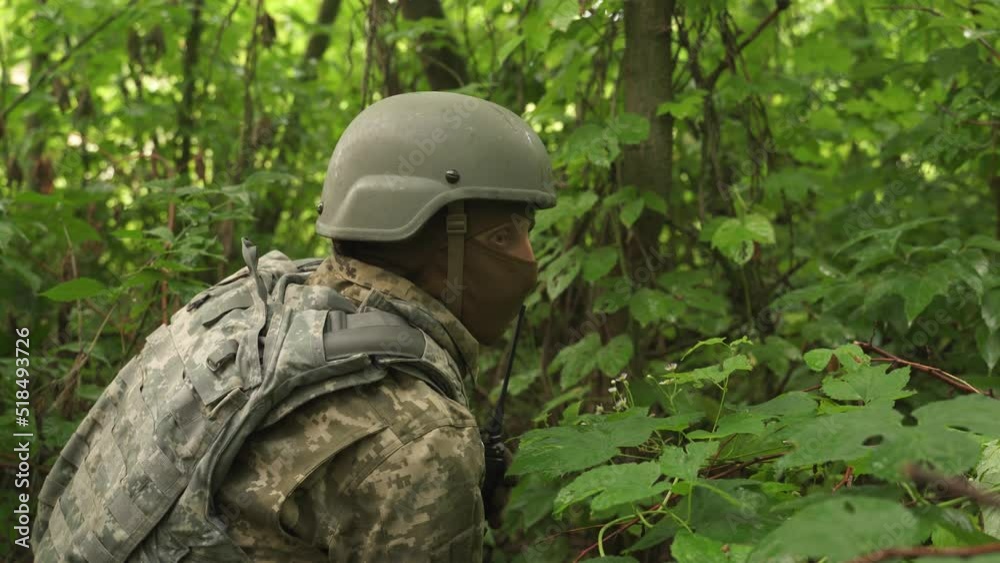 a soldier watching the enemy army in a forest shelter . Ukrainian soldier hides from enemy attack in the forest. shelling. mortar shelling, aircraft attack on infantry positions. combat operations a soldier watching the enemy army in a forest shelter . Ukrainian soldier hides from enemy attack in the forest. shelling. mortar shelling, aircraft attack on infantry positions. combat operations